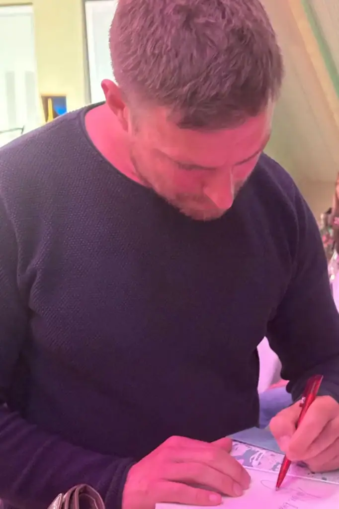 Leo Reisinger signiert ein Buch